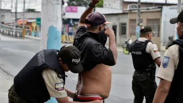Policista prohledává muže