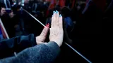 Izraelské ženy kladou ruku na vozidlo konvoje s rakvemi Širi Bibasové a jejích dvou dětí
